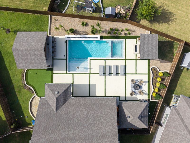 Drone view of a rectangular gunite pool with a turf grid deck and cabana