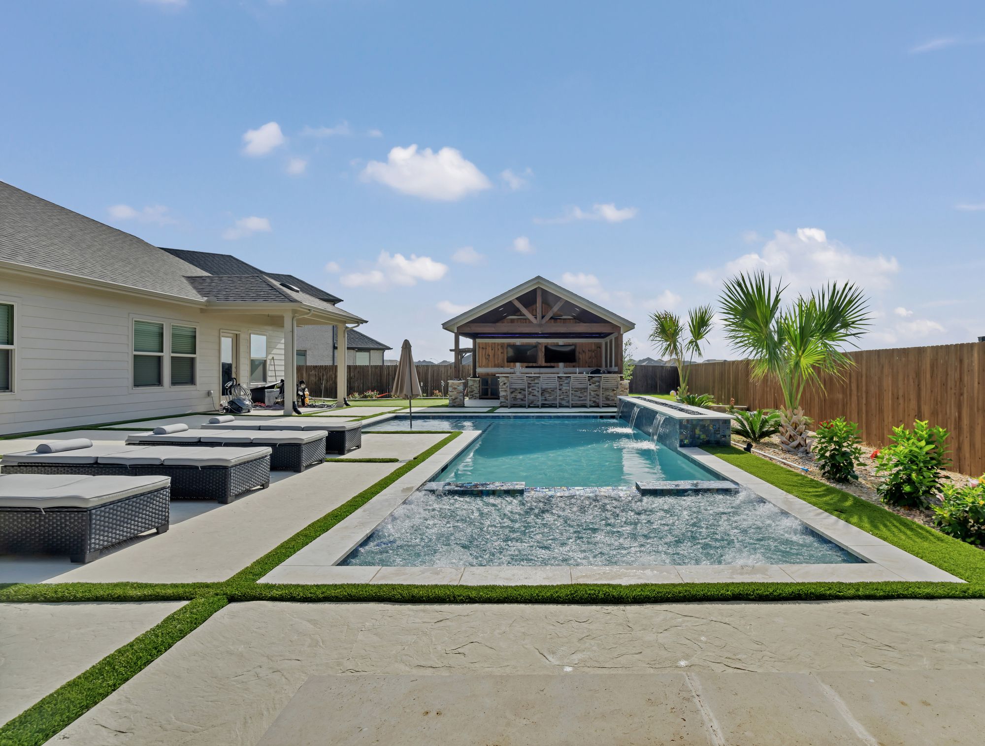 Long gunite pool with a turf grid deck and a timber pavilion