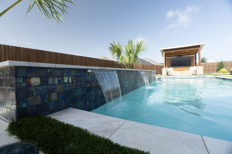 Sheer descents falling from a raised glass tile wall
