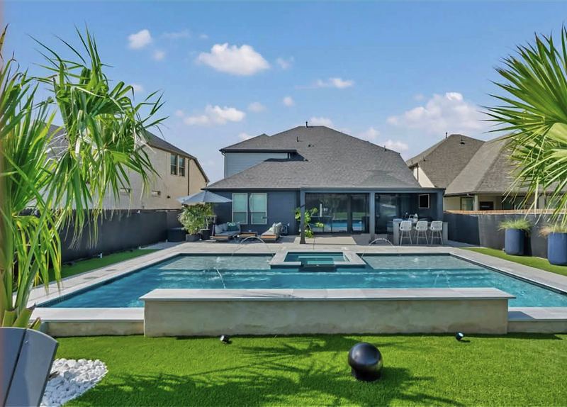 Finished pool and raised spa with turf surround
