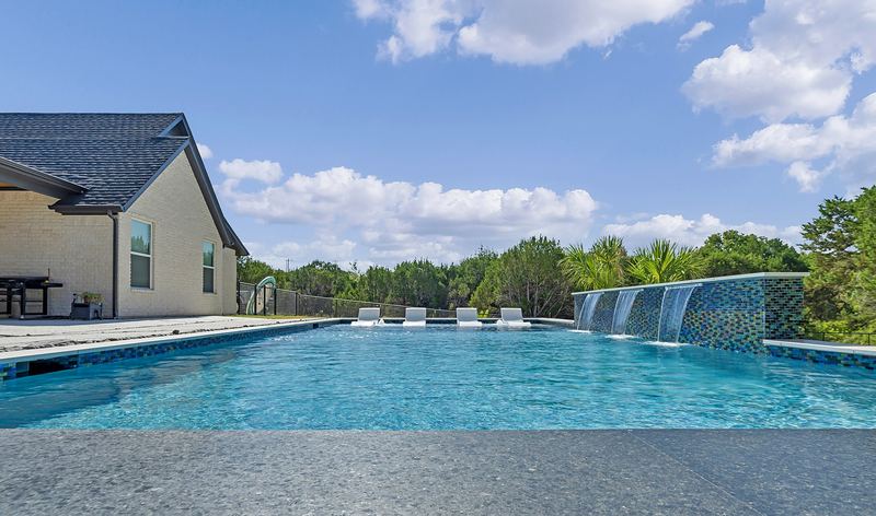 Finished gunite pool with a glass tile sheer descent wall